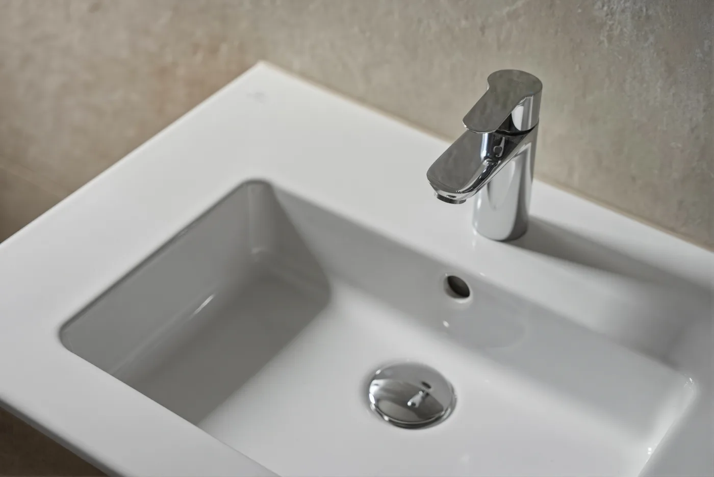 Detail keramického umyvadla s chromovou baterií