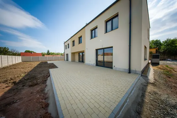 Zadní fasáda s velkou dlážděnou terasou a francouzskými okny