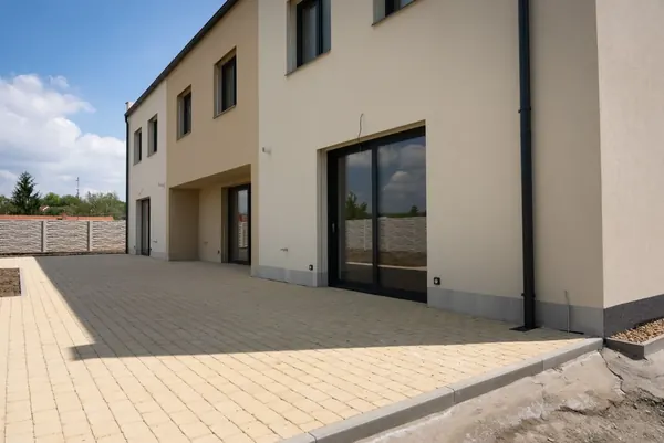 Zahradní strana trojdomu s prosklenými HS portály a terasou