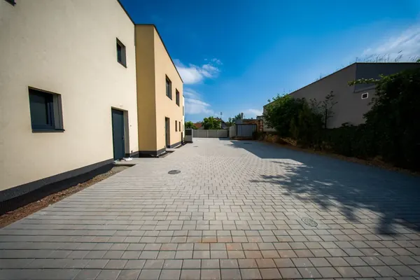 Vstupní strana domu s dlážděným parkovacím dvorem