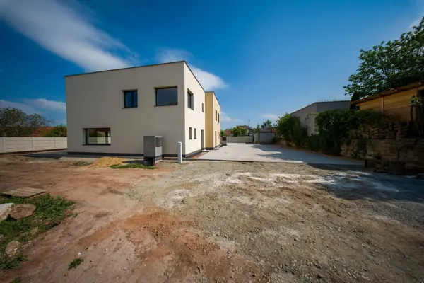 Boční a čelní pohled na trojdům s příjezdovou dlažbou